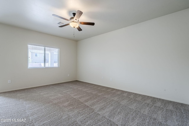 spare room featuring carpet, visible vents, baseboards, and a ceiling fan