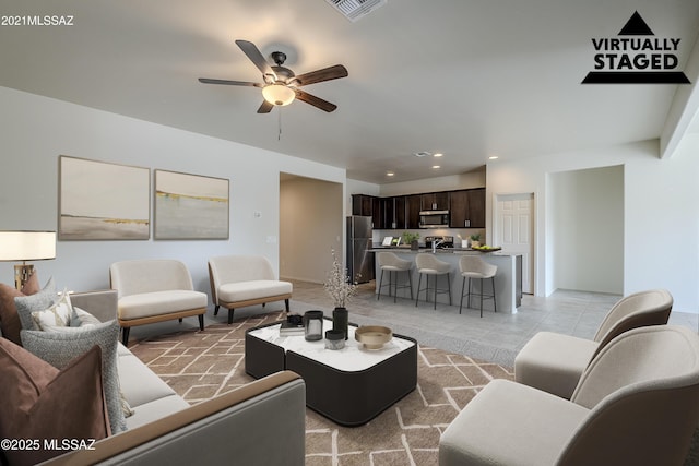 living area featuring light tile patterned flooring, ceiling fan, visible vents, and recessed lighting