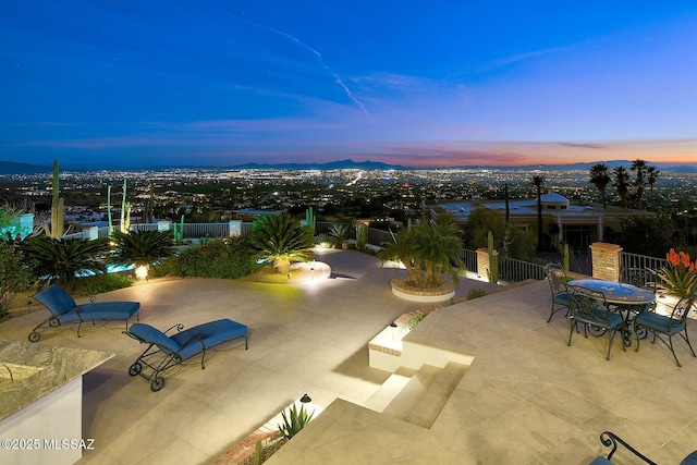 patio terrace at dusk featuring a mountain view