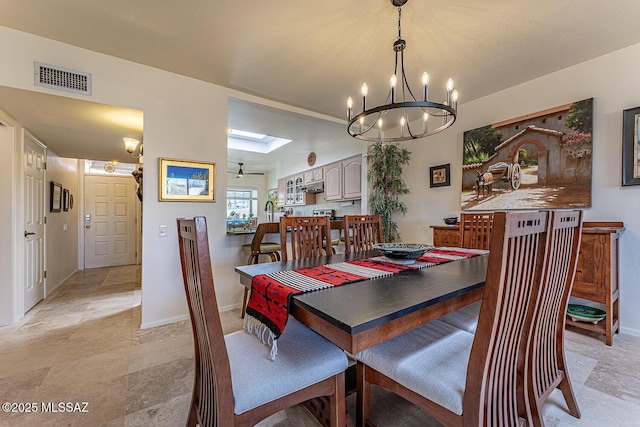 dining space featuring a skylight, baseboards, and visible vents