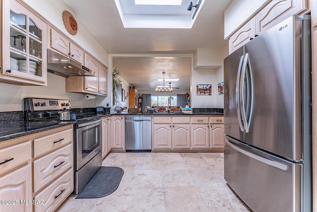 kitchen featuring under cabinet range hood, a sink, an inviting chandelier, appliances with stainless steel finishes, and glass insert cabinets