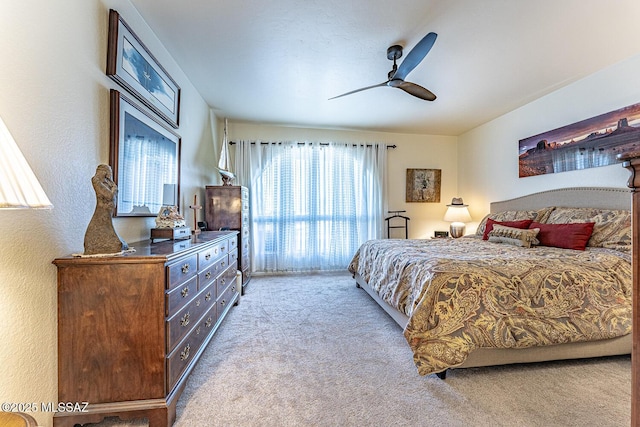 carpeted bedroom featuring a textured wall and ceiling fan