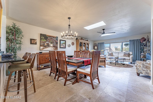 dining area with a notable chandelier, a skylight, and a textured ceiling