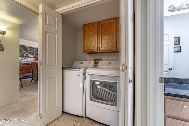 clothes washing area with cabinet space and separate washer and dryer