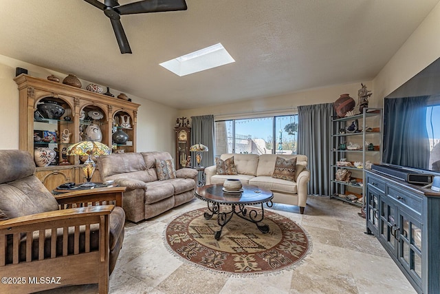 living room with vaulted ceiling with skylight, a textured ceiling, and stone finish floor