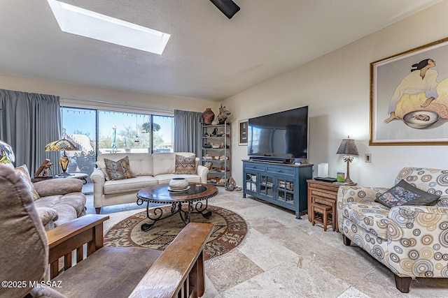 living area featuring vaulted ceiling with skylight and a textured ceiling