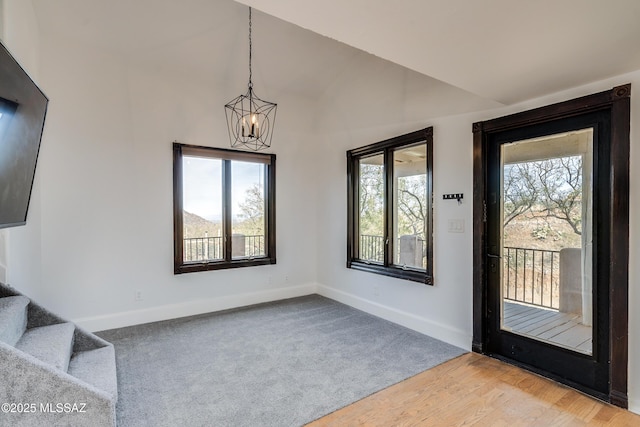 foyer with lofted ceiling, light colored carpet, a notable chandelier, baseboards, and stairway