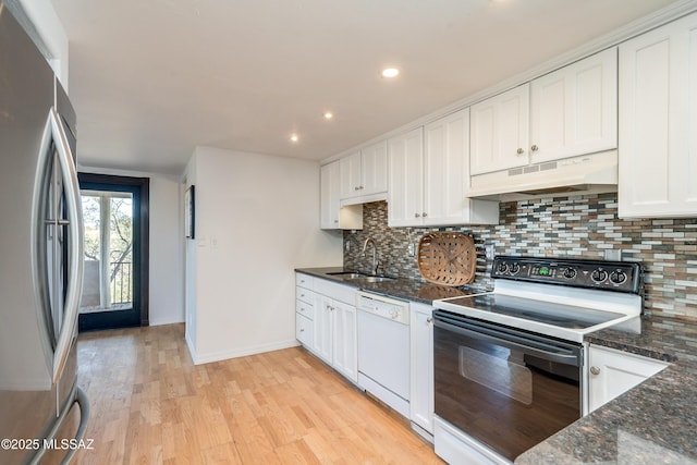 kitchen featuring white dishwasher, under cabinet range hood, a sink, electric stove, and freestanding refrigerator