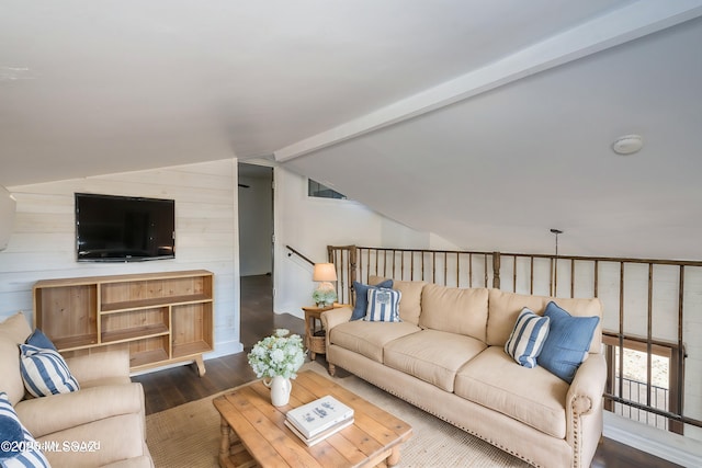 living room featuring dark wood-style floors, lofted ceiling with beams, and wooden walls