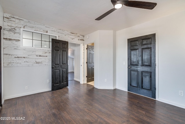 interior space featuring dark wood-type flooring, baseboards, and a ceiling fan