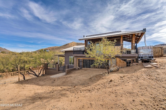 rear view of house with a mountain view and stucco siding