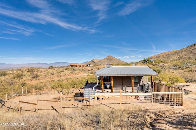 back of house featuring a mountain view, metal roof, and an exterior structure