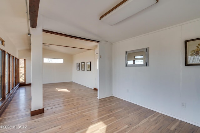 unfurnished room featuring lofted ceiling with beams and light wood finished floors