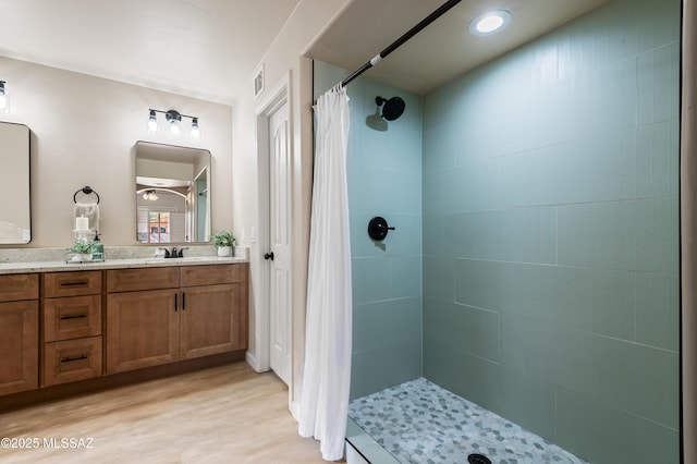 bathroom with a shower with shower curtain, vanity, and hardwood / wood-style flooring