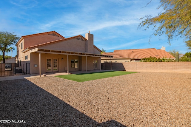 rear view of property featuring french doors, central AC, and a patio area