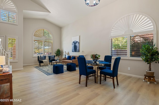 dining room with light hardwood / wood-style floors and lofted ceiling