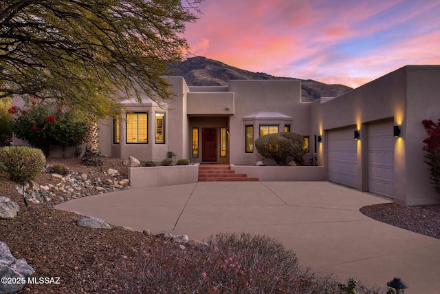 pueblo-style house with a mountain view and a garage