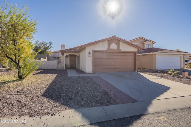 view of front of home featuring a garage, a chimney, concrete driveway, and stucco siding