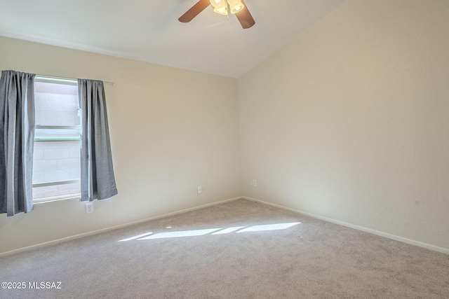 unfurnished room with lofted ceiling, ceiling fan, carpet flooring, and baseboards