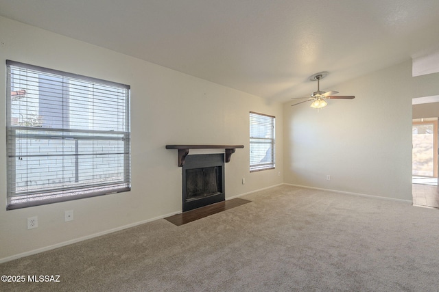 unfurnished living room with lofted ceiling, carpet, a ceiling fan, and a fireplace with flush hearth