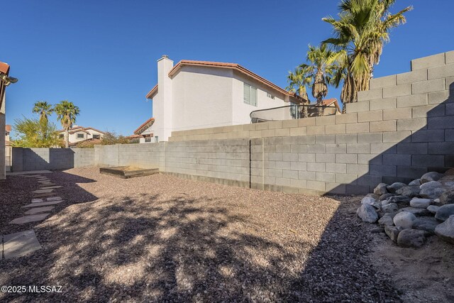 back of house featuring central AC unit and an outdoor fire pit