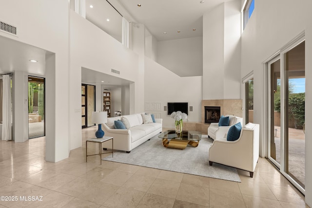 6872 E Desert Wind Ct, Tucson, AZ 85750 - living room with healthy amount of natural light, a high ceiling, a tiled fireplace, recessed lighting, and light tile patterned flooring