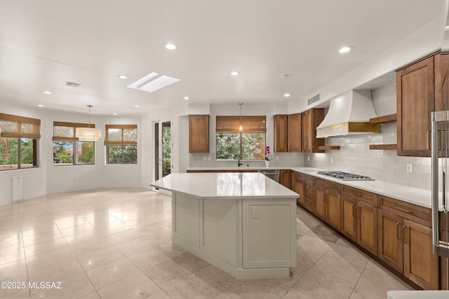 6872 E Desert Wind Ct, Tucson, AZ 85750 - kitchen with custom exhaust hood, stainless steel appliances, brown cabinets, light countertops, and recessed lighting