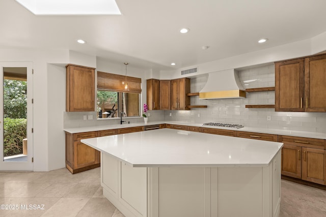 6872 E Desert Wind Ct, Tucson, AZ 85750 - kitchen with open shelves, brown cabinets, custom exhaust hood, a kitchen island, and recessed lighting