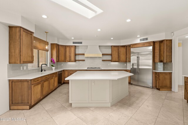 6872 E Desert Wind Ct, Tucson, AZ 85750 - kitchen featuring appliances with stainless steel finishes, custom exhaust hood, brown cabinets, and recessed lighting