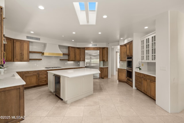 6872 E Desert Wind Ct, Tucson, AZ 85750 - kitchen featuring stainless steel appliances, custom range hood, beverage cooler, open shelves, and tasteful backsplash