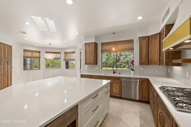 6872 E Desert Wind Ct, Tucson, AZ 85750 - kitchen featuring appliances with stainless steel finishes, a skylight, recessed lighting, backsplash, and hanging light fixtures