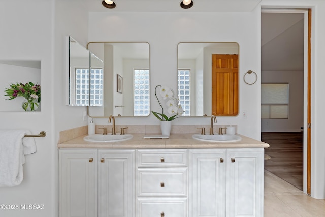 bathroom with a sink, double vanity, and tile patterned floors