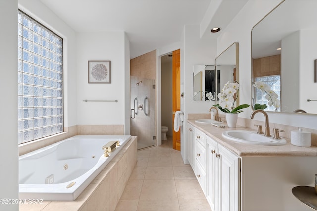 full bathroom with a sink, toilet, a jetted tub, and tile patterned flooring