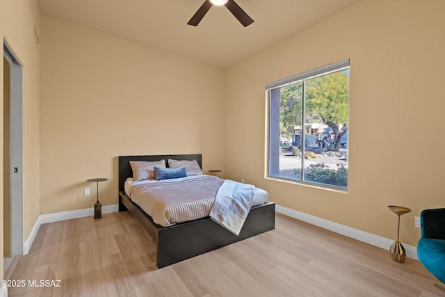 bedroom with light wood-type flooring, baseboards, and ceiling fan