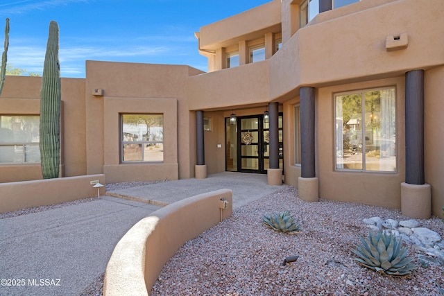 property entrance with stucco siding