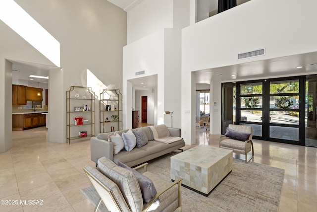 living room featuring light tile patterned flooring, visible vents, and french doors