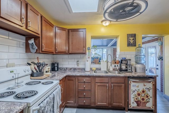 kitchen with light stone countertops, tasteful backsplash, stainless steel dishwasher, sink, and white electric stove