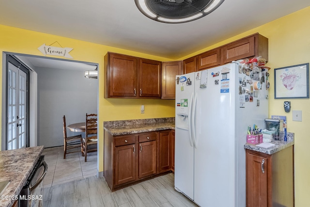 kitchen featuring dishwasher, white fridge with ice dispenser, and light hardwood / wood-style floors