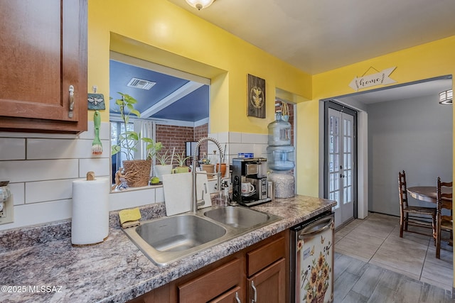 kitchen with dishwasher, decorative backsplash, and sink