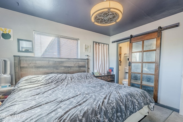 bedroom with connected bathroom and a barn door