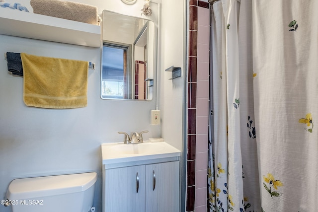 bathroom with a shower with shower curtain, vanity, and toilet