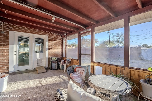 sunroom featuring vaulted ceiling with beams