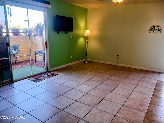 spare room with light tile patterned flooring and baseboards