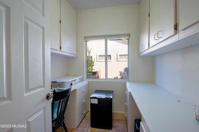 clothes washing area with light tile patterned floors