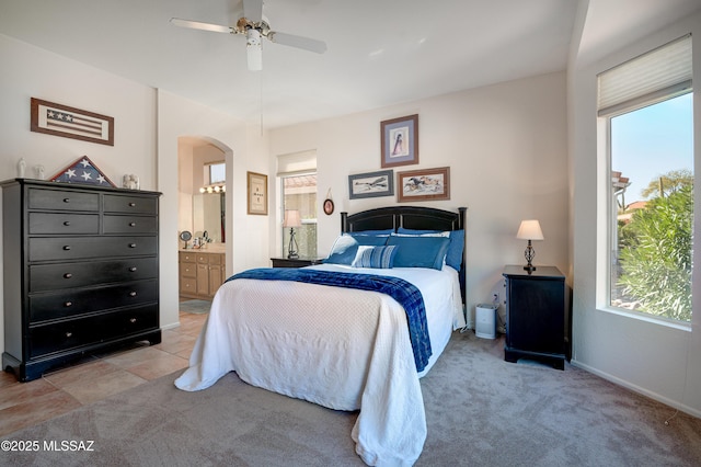 carpeted bedroom with ceiling fan and ensuite bath