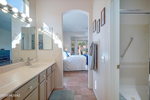 bathroom with walk in shower, vanity, and tile patterned flooring