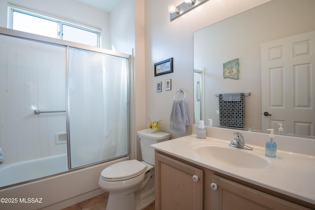 full bathroom with combined bath / shower with glass door, vanity, toilet, and tile patterned flooring