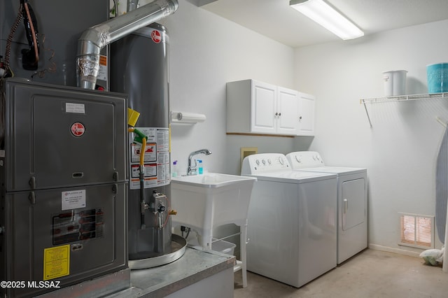 washroom featuring cabinets, washer and clothes dryer, and heating unit