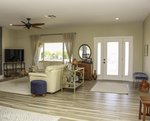 living room with ceiling fan and light hardwood / wood-style flooring