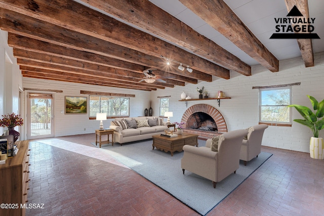 living area featuring brick floor, beamed ceiling, a brick fireplace, and brick wall